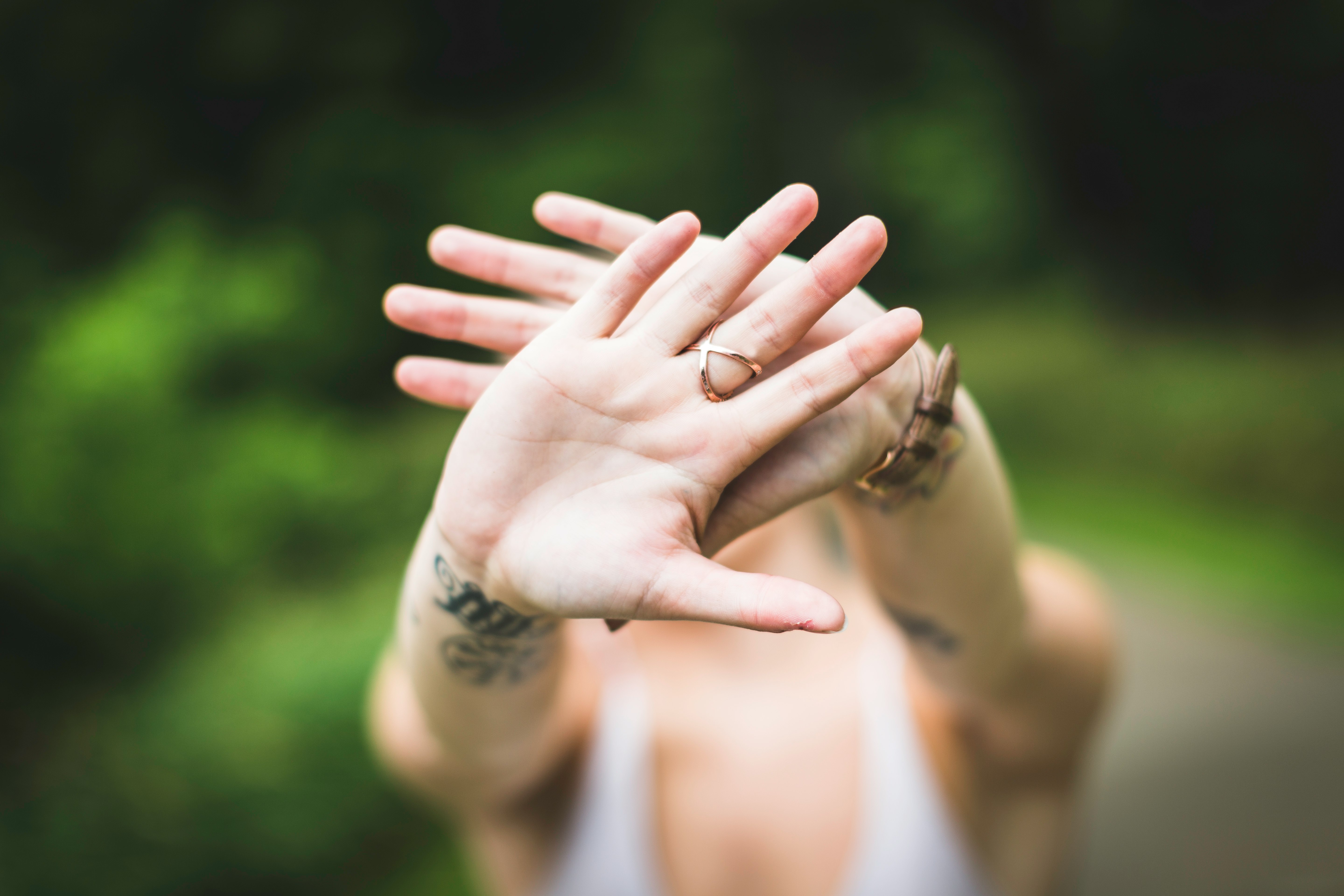 selective focus photo of person's hand with gold-colored ring in it